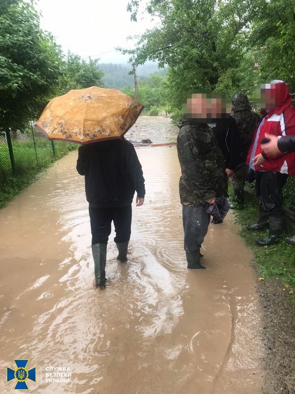 люди в резиновых сапогах бродят по воде